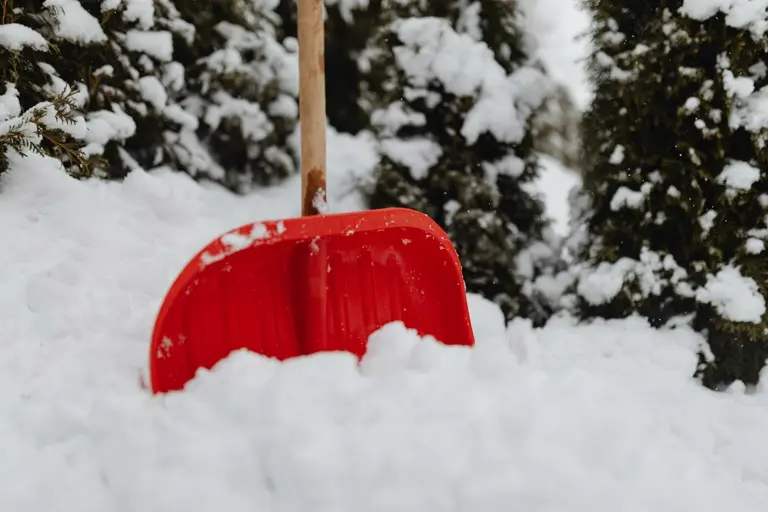Winterdienst Berlin — rote Schneeschaufel im frisch gefallenen Schnee